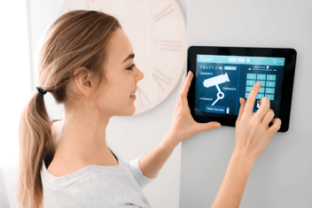 Eine junge Frau tippt einen Zahlencode auf einem Tablet ein.