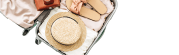 geöffneter Reisekoffer mit Hut und Sandalen