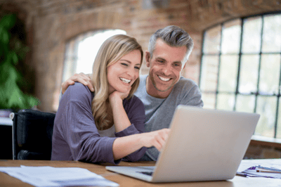 A couple sitting in front of a laptop