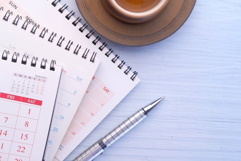 Drei Kalender und ein Stift auf einem Schreibtisch